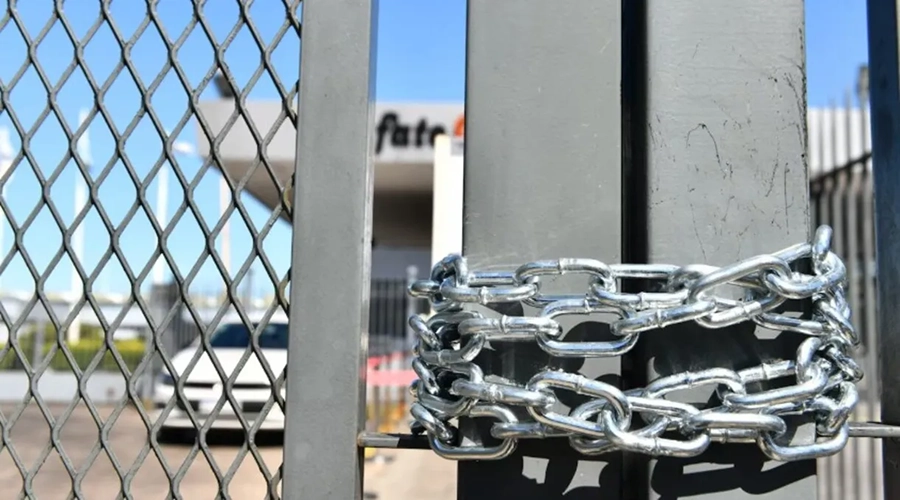 Portón de acceso a fábrica de Fate con cadenas
