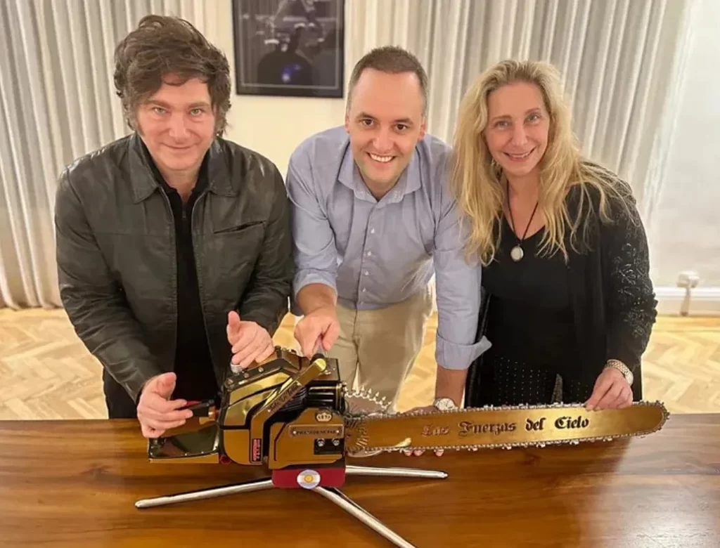 Javier Milei, Adorni, Karina Milei mostrando una motosierra